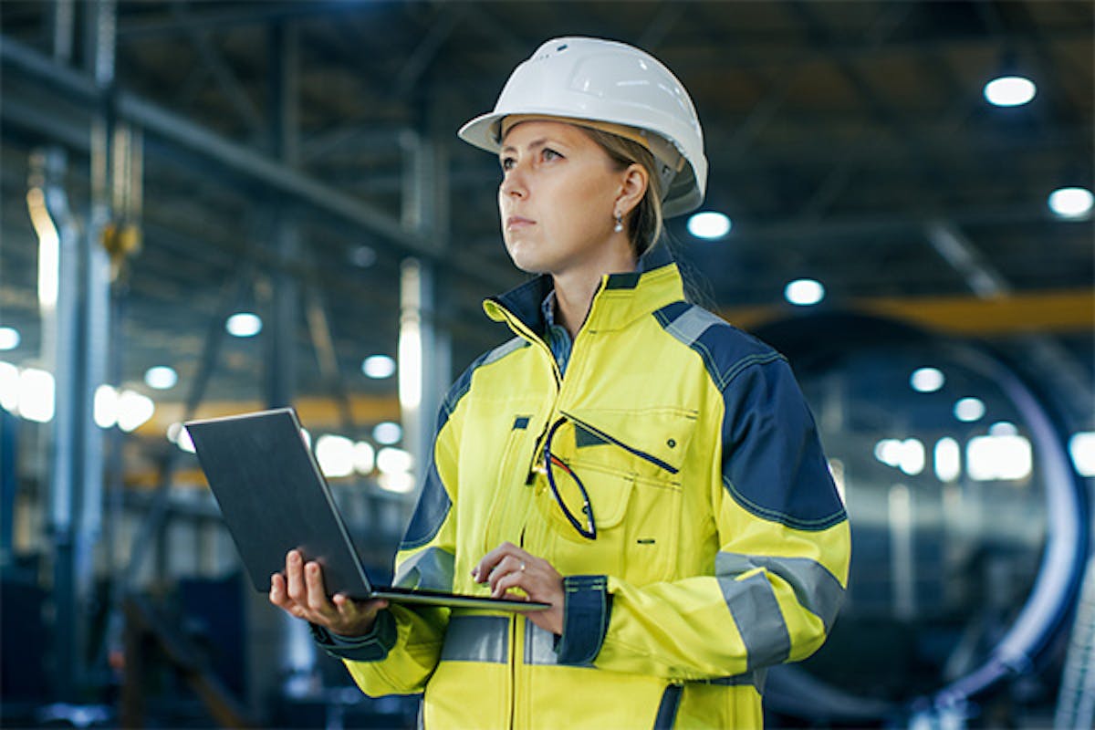 Woman holding a laptop in a factory