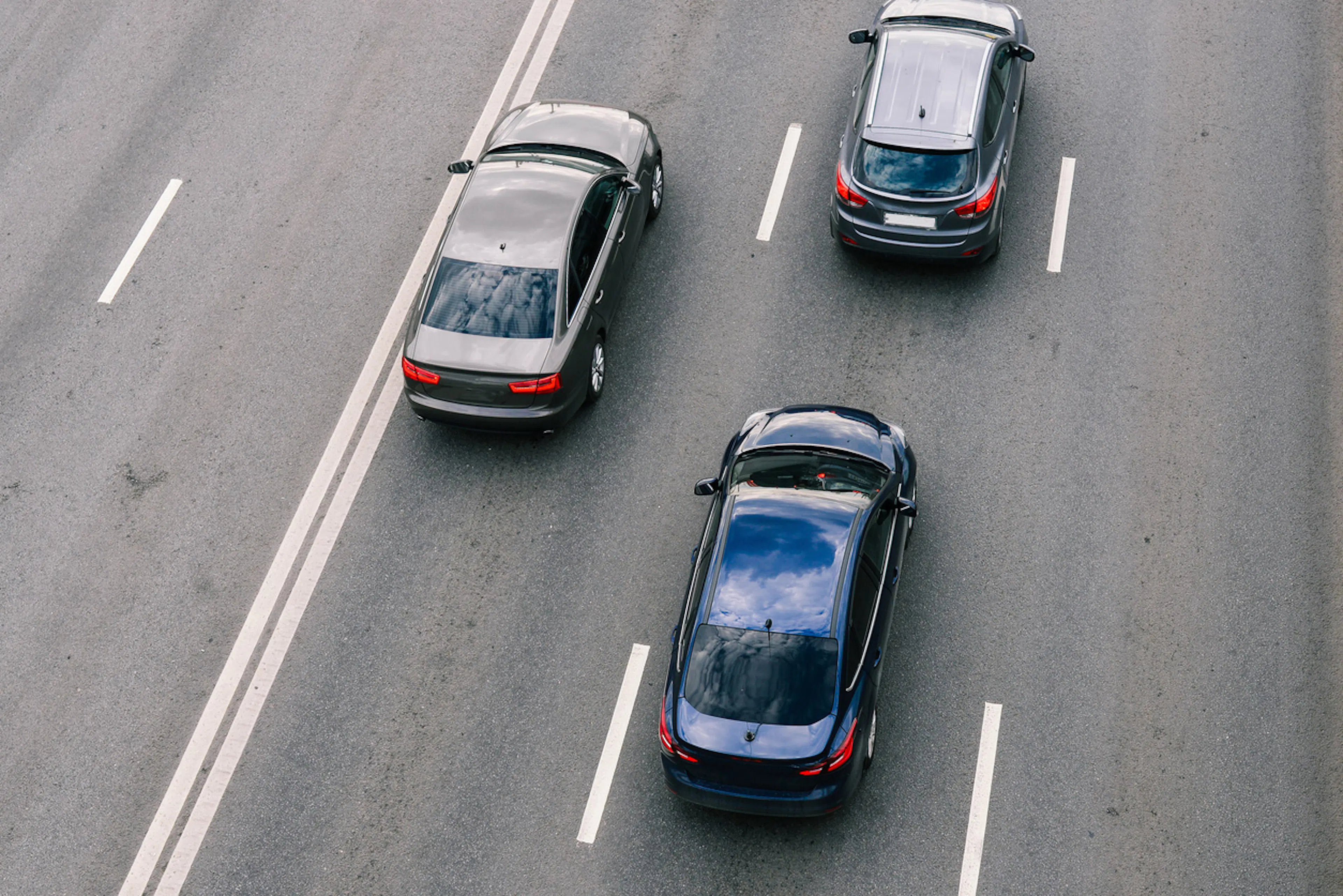three cars driving on a highway