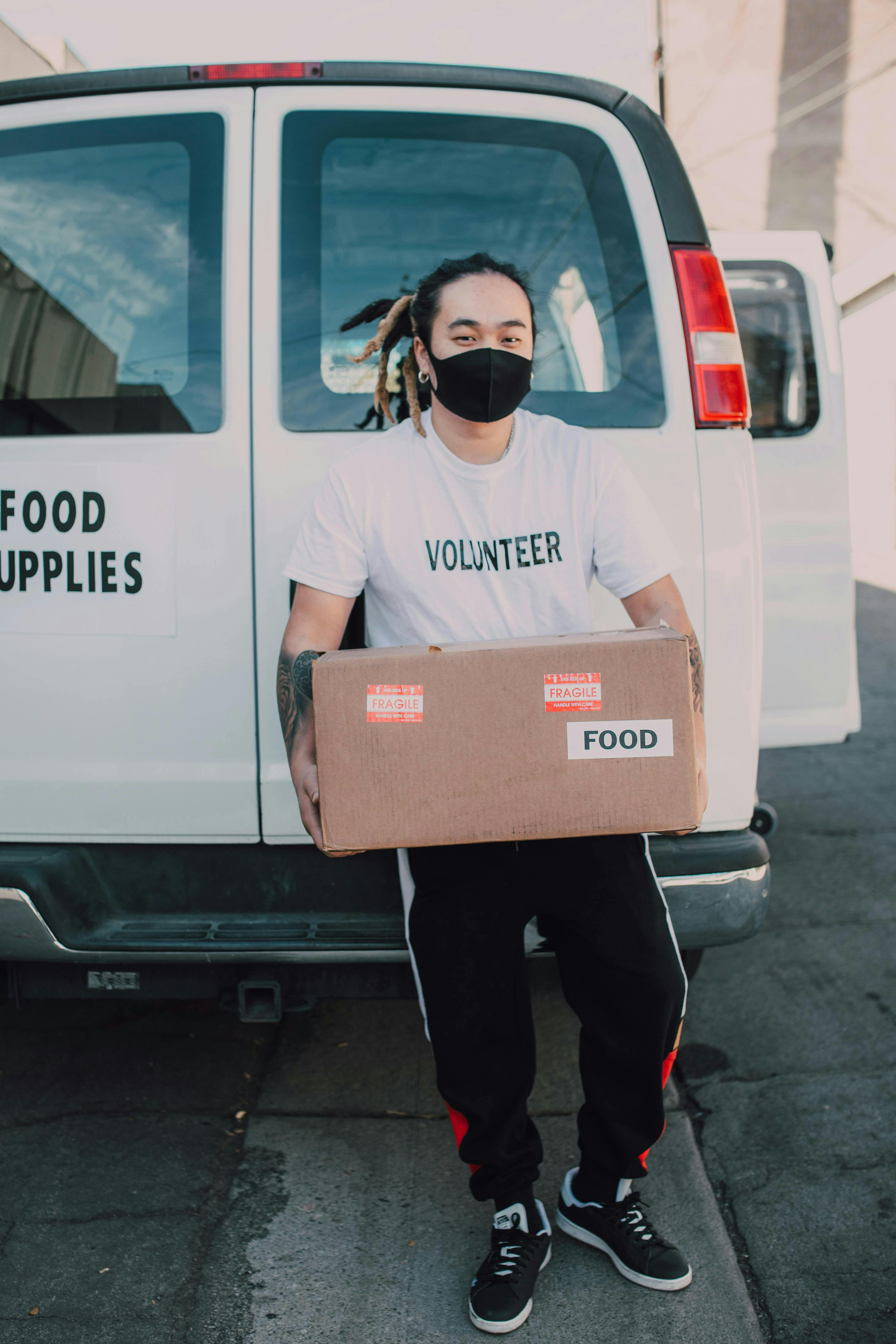 food bank volunteer carrying a box of food