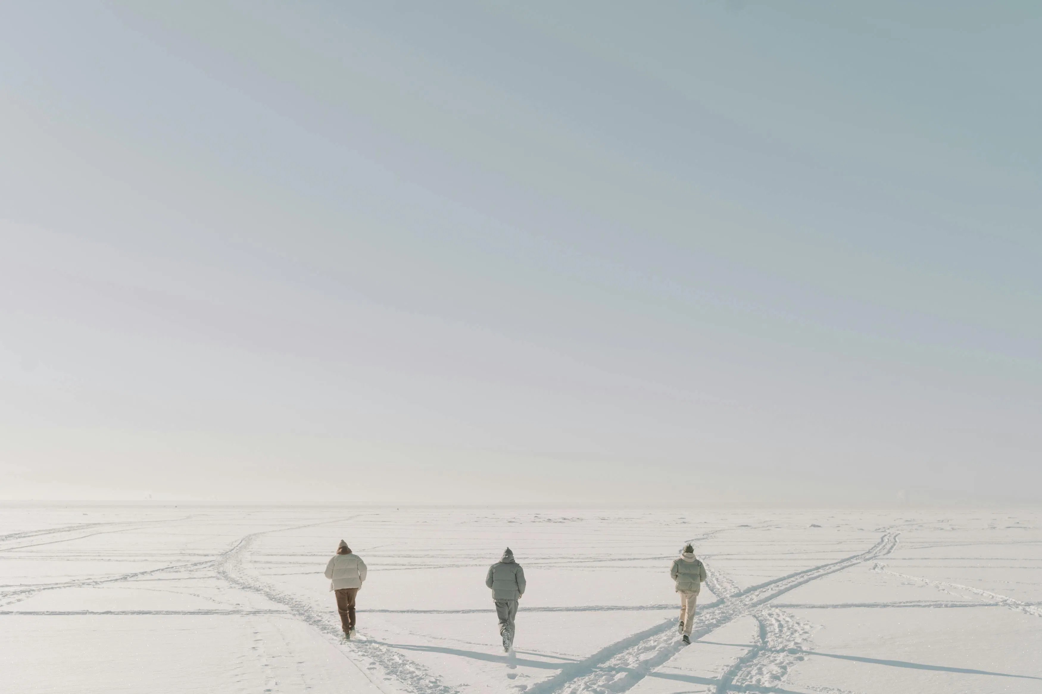 three people walking in the snow