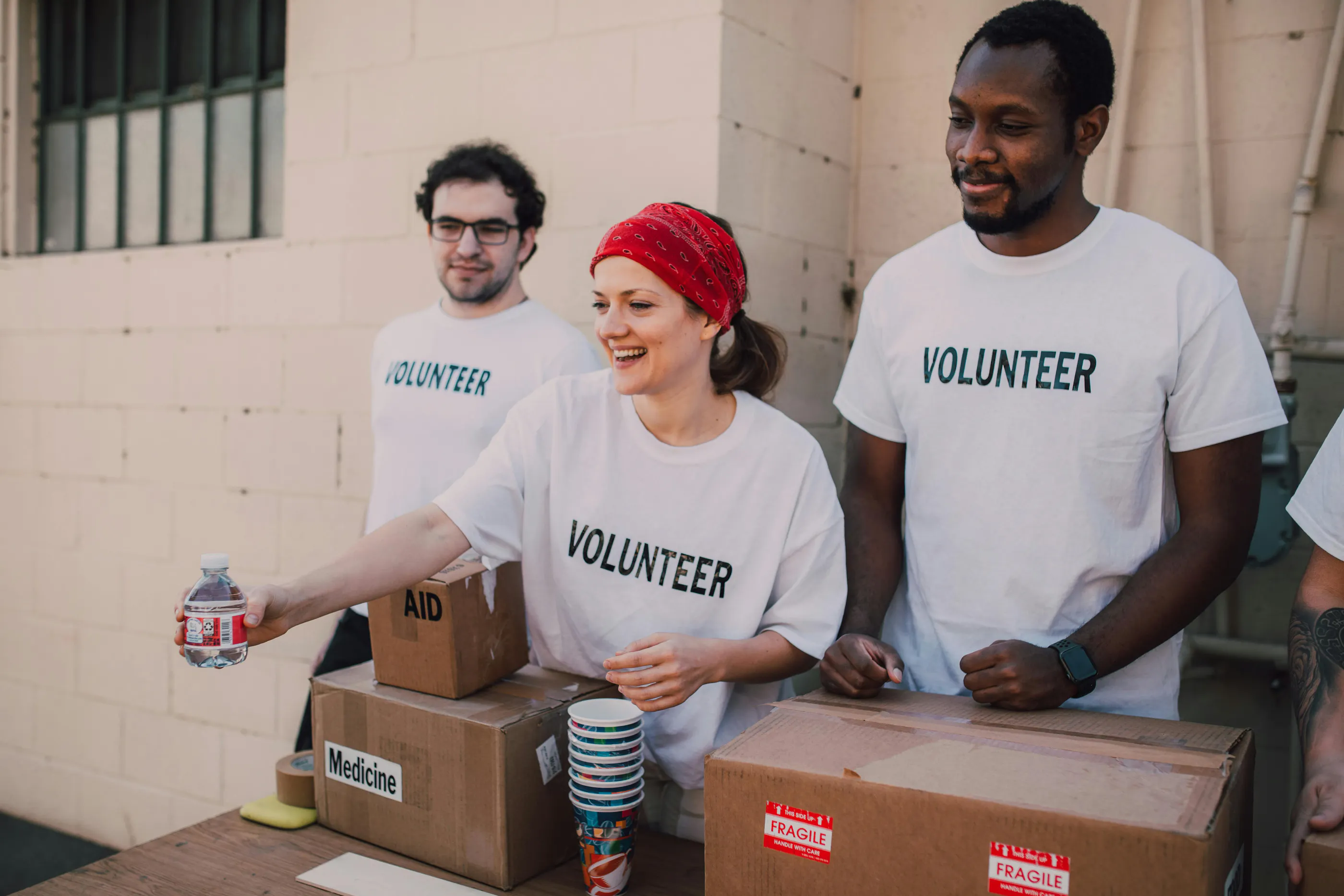 three volunteers handing out supplies