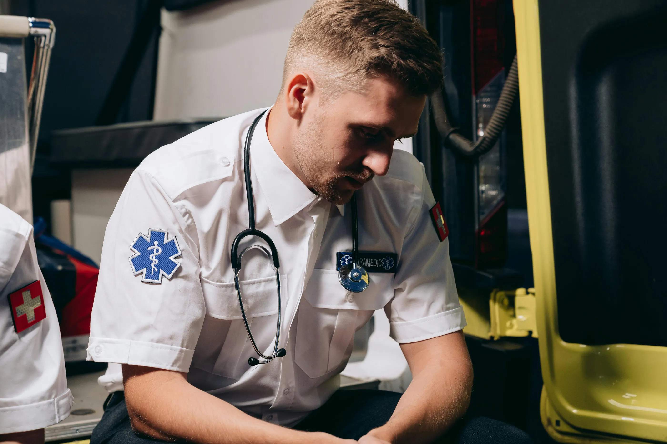 EMT sitting in ambulance with his face in shadow