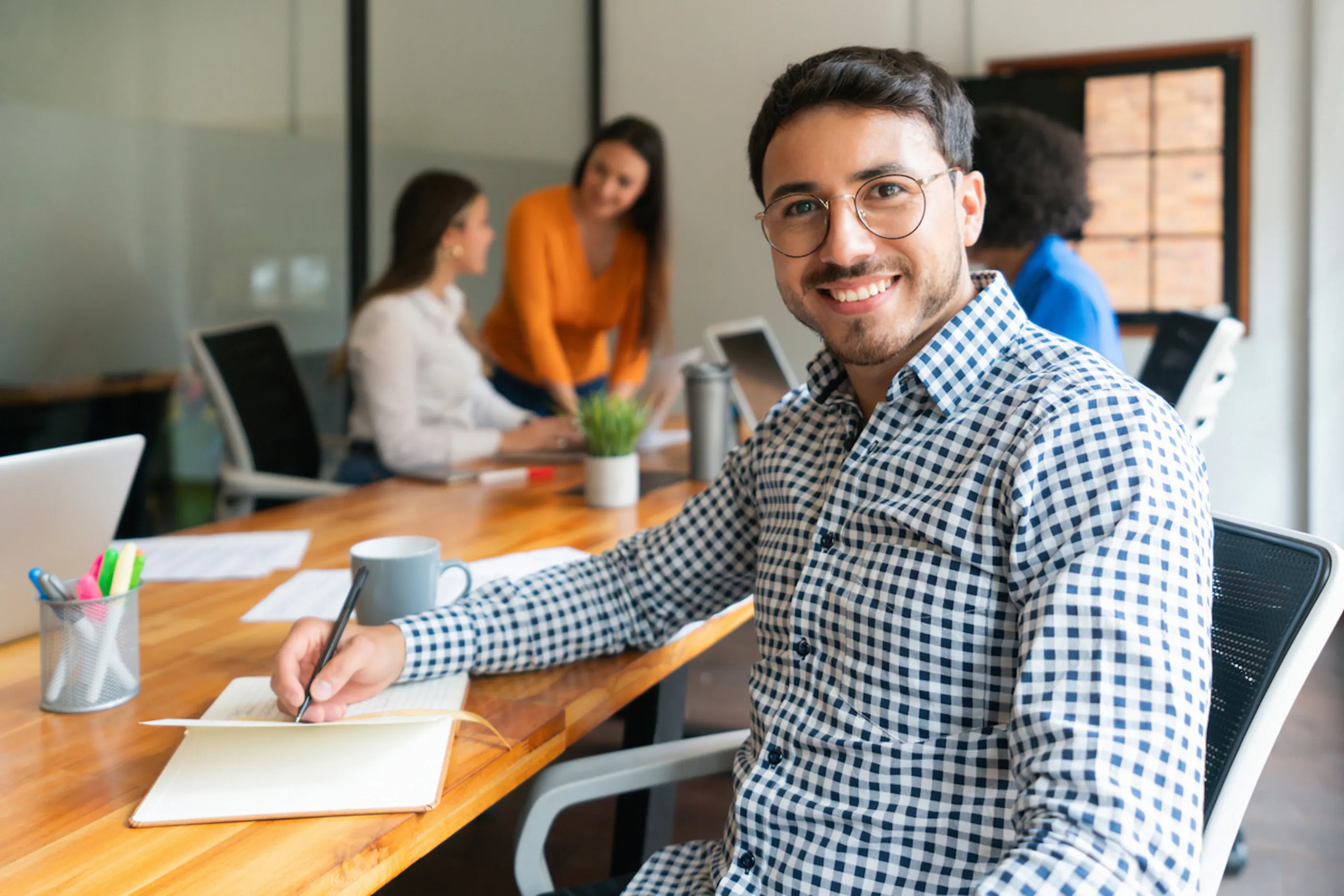 man taking notes at conference table