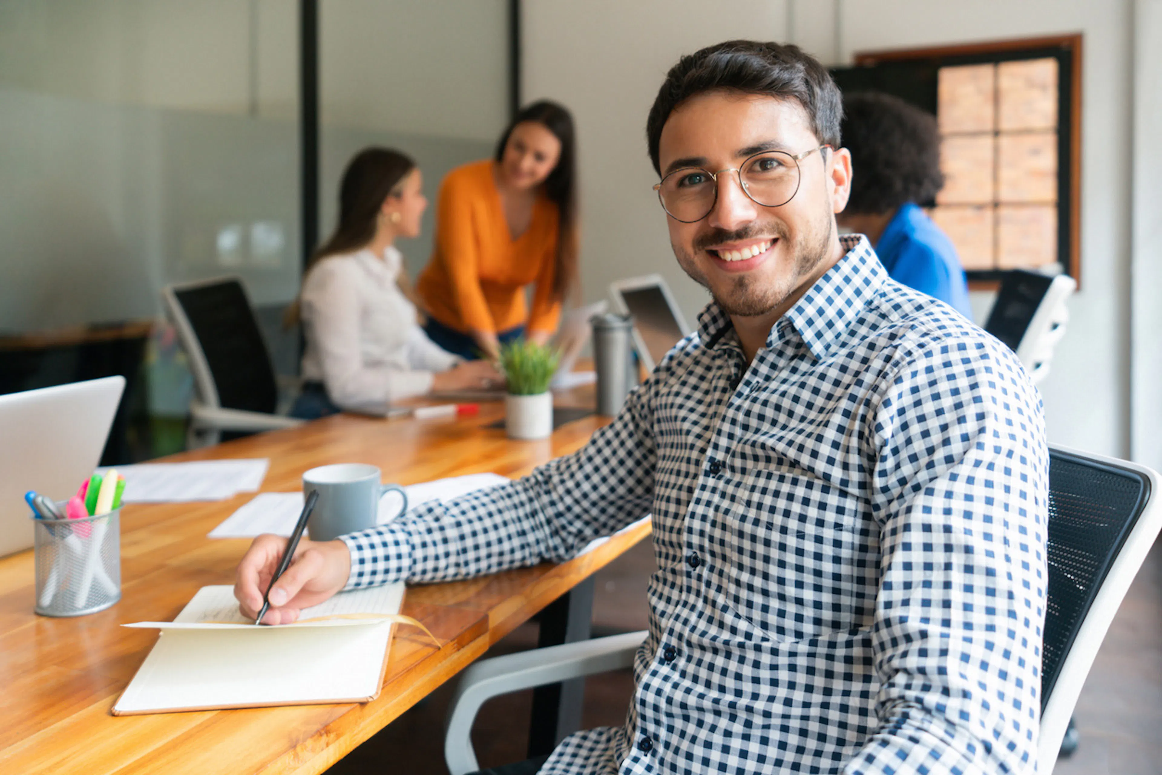 man taking notes at conference table