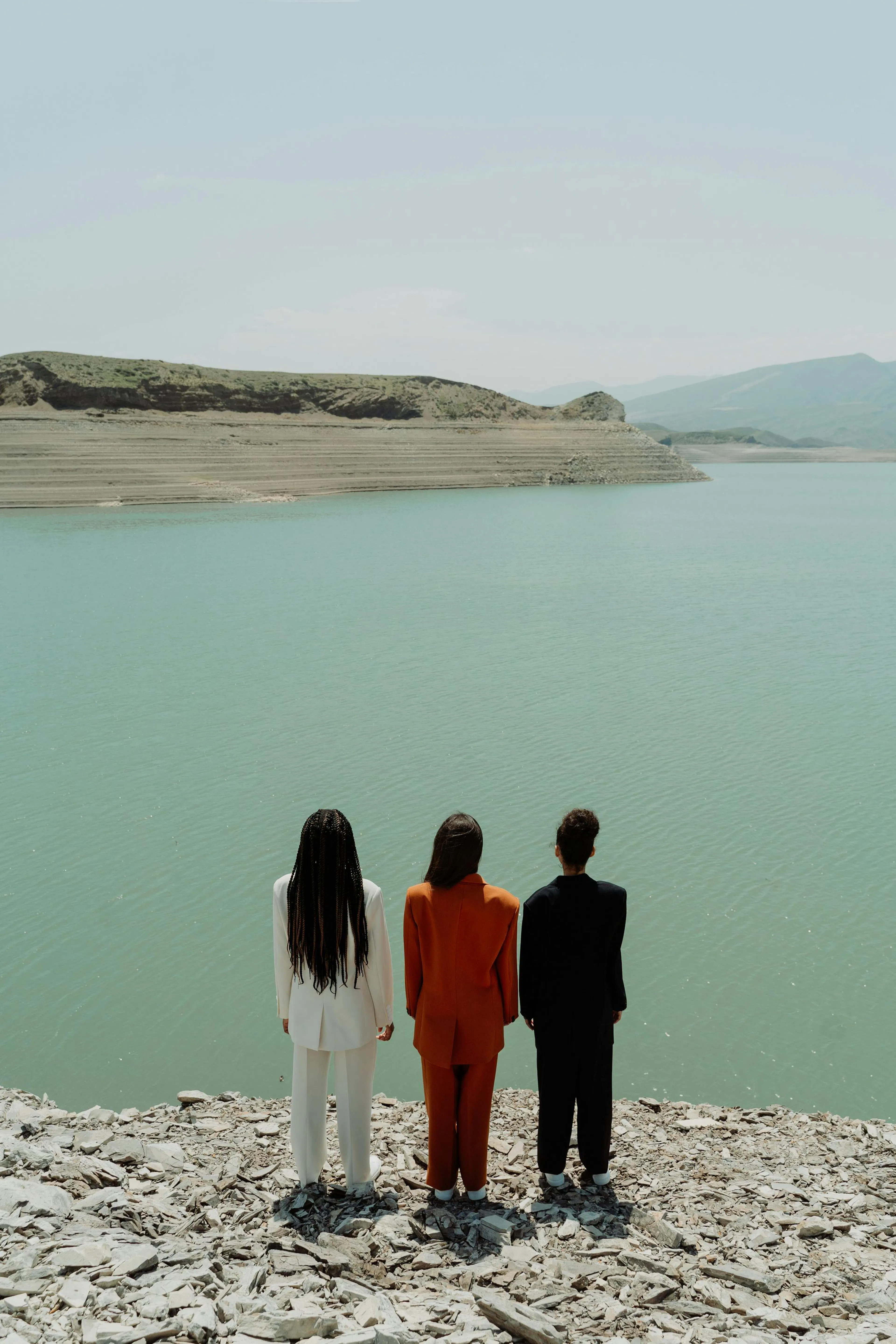 three people standing by water