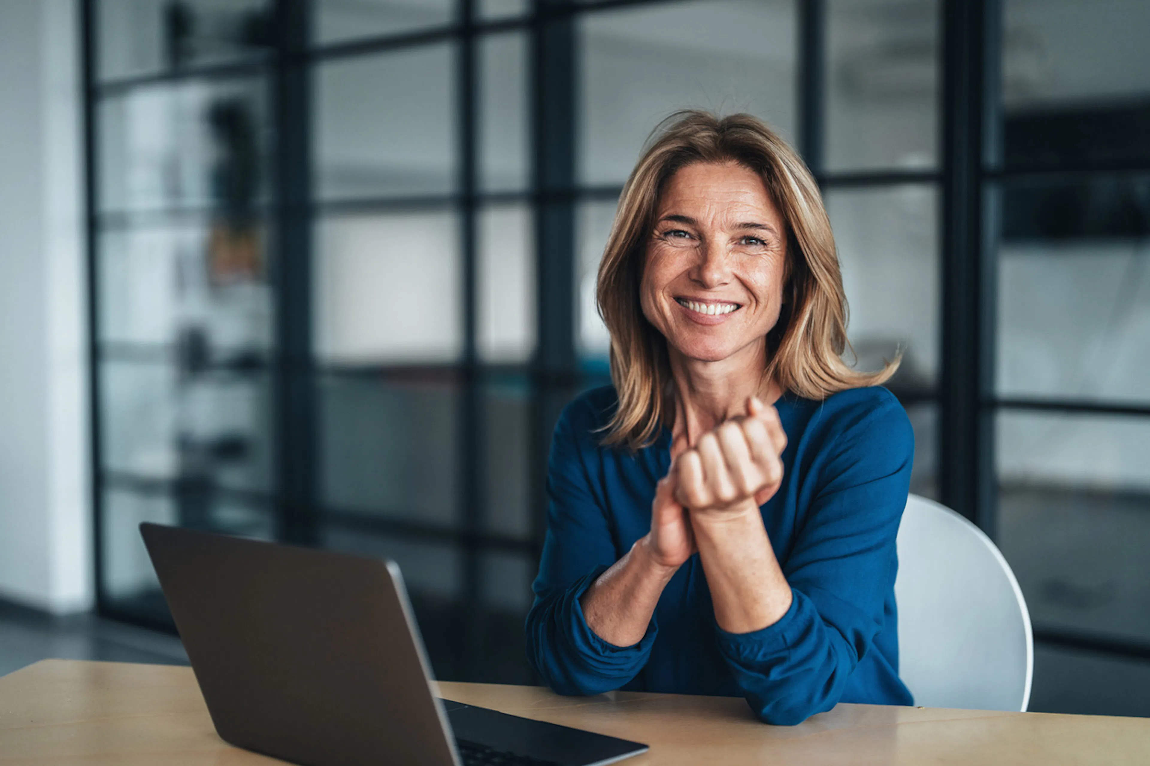 woman sitting at a conference table in front of a laptop