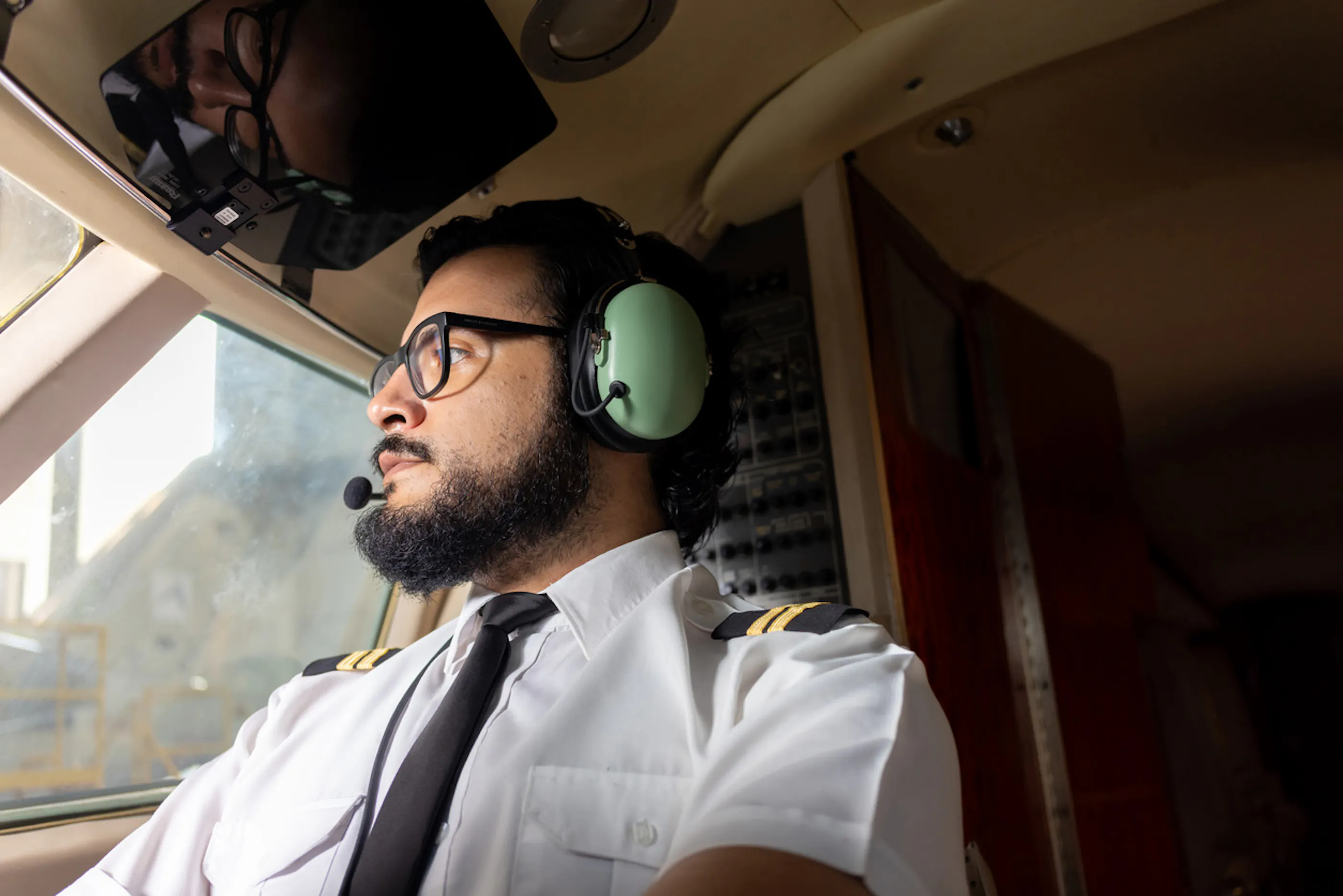 pilot wearing headphones in cockpit