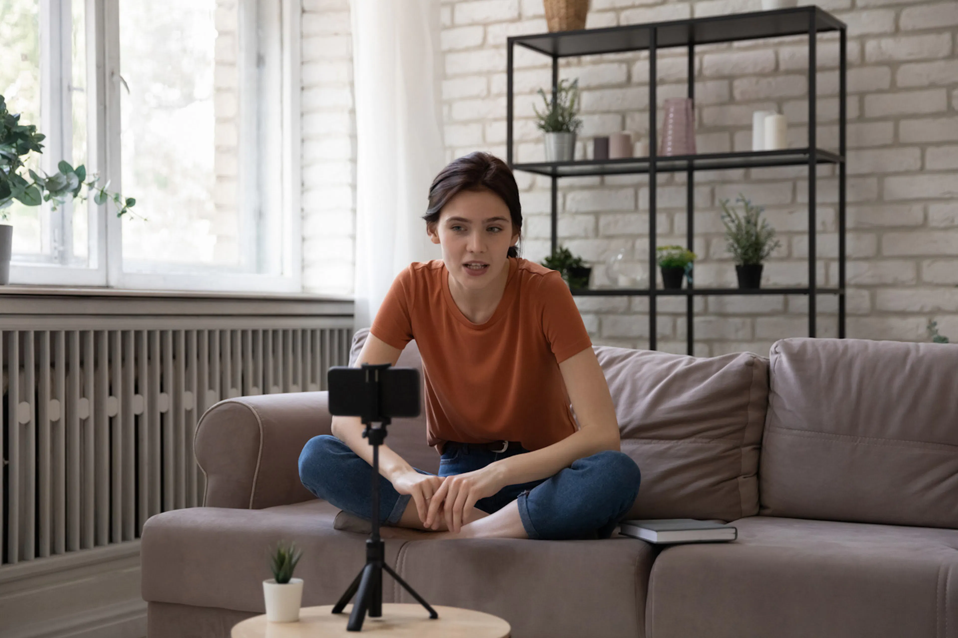 woman on sofa in front of cellphone web cam