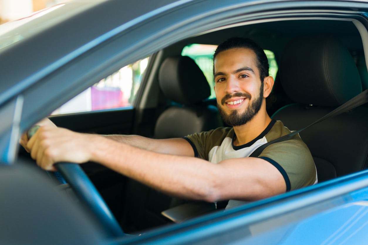 rideshare driver smiling behind the wheel