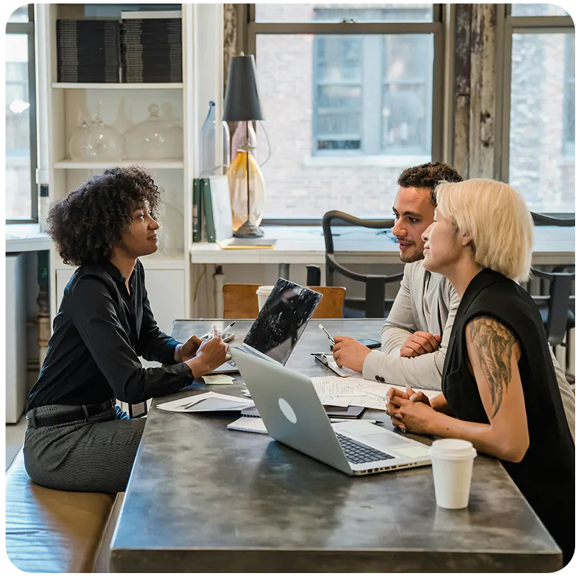 three people working at a desk together
