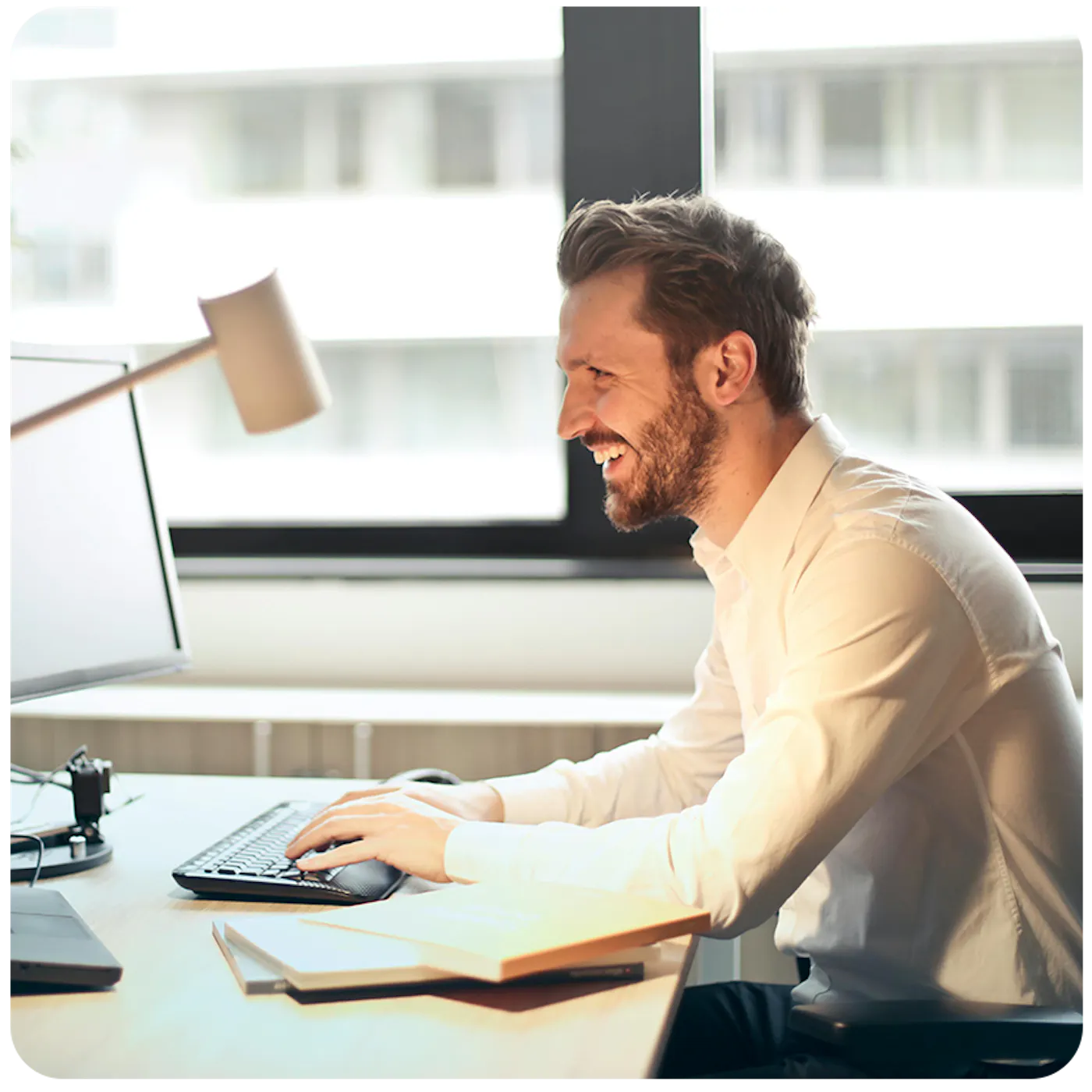 man working on a computer and smiling