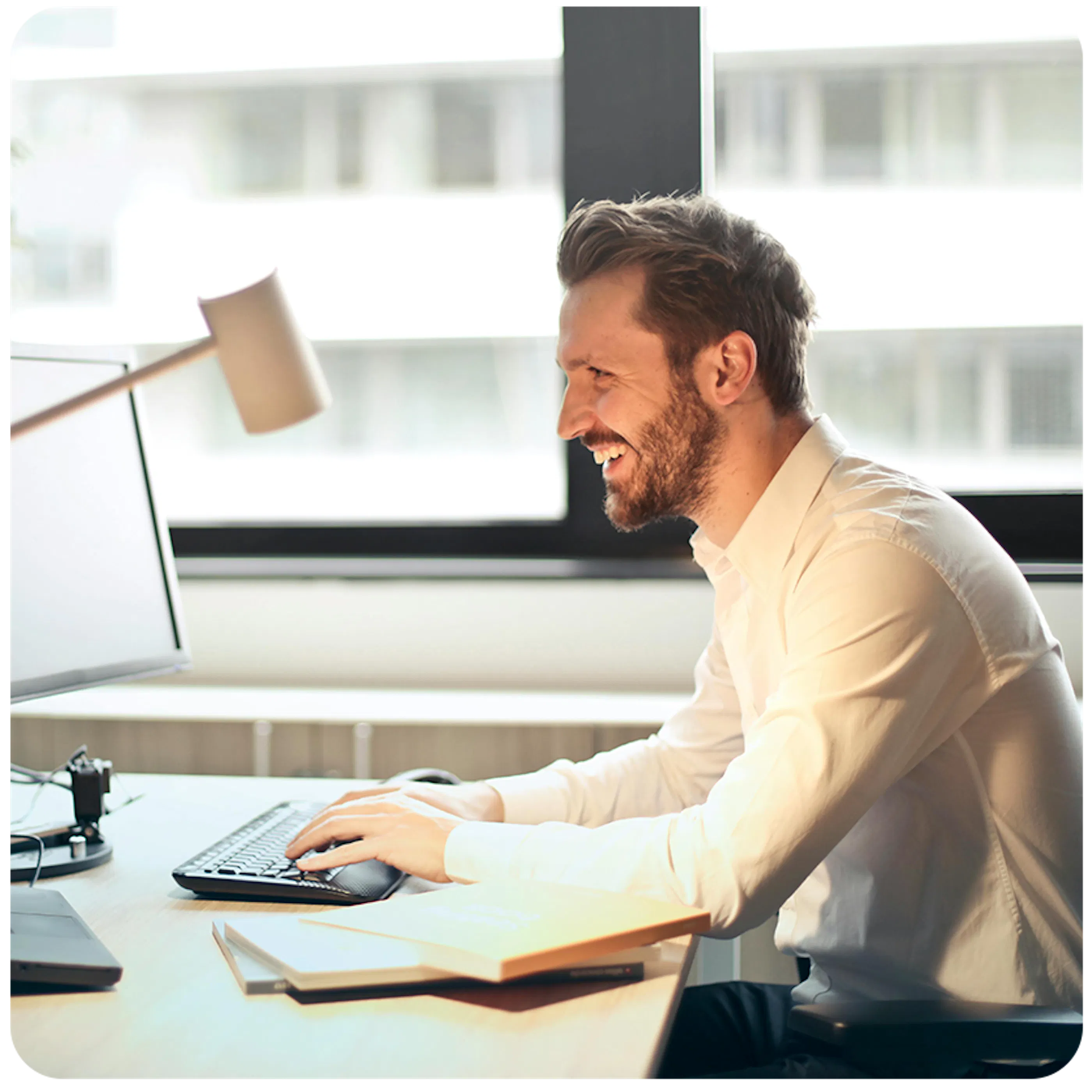 man working on a computer and smiling