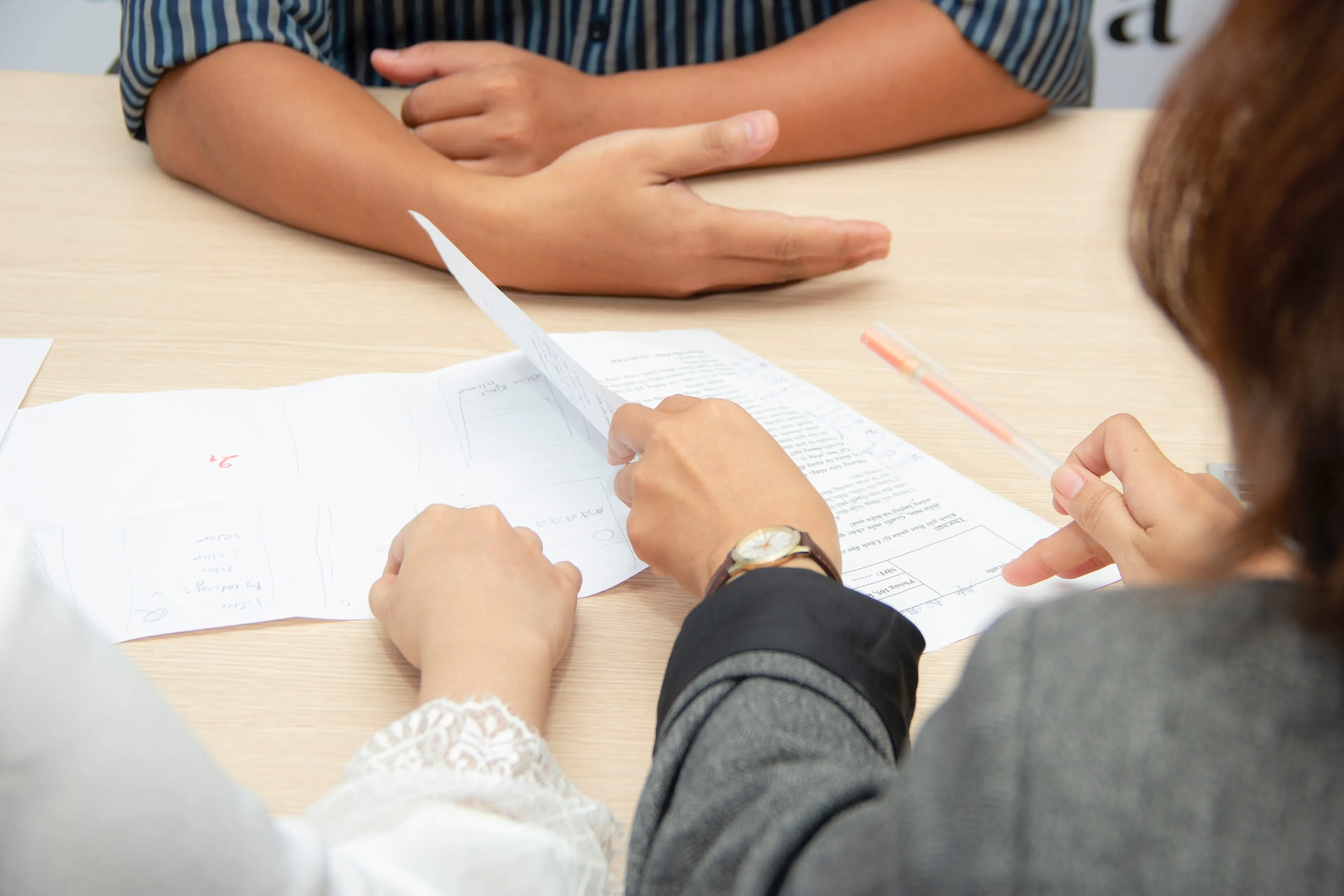 three people reviewing documents on a conference table