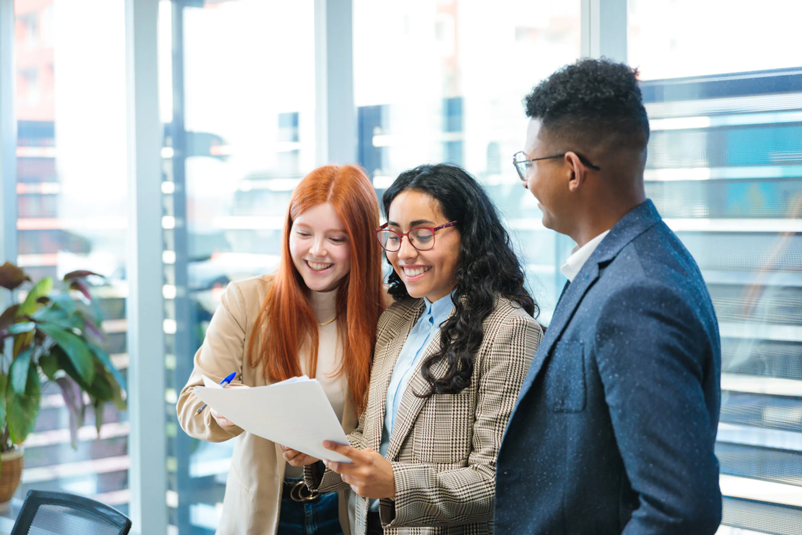 3 young business professionals looking over a report