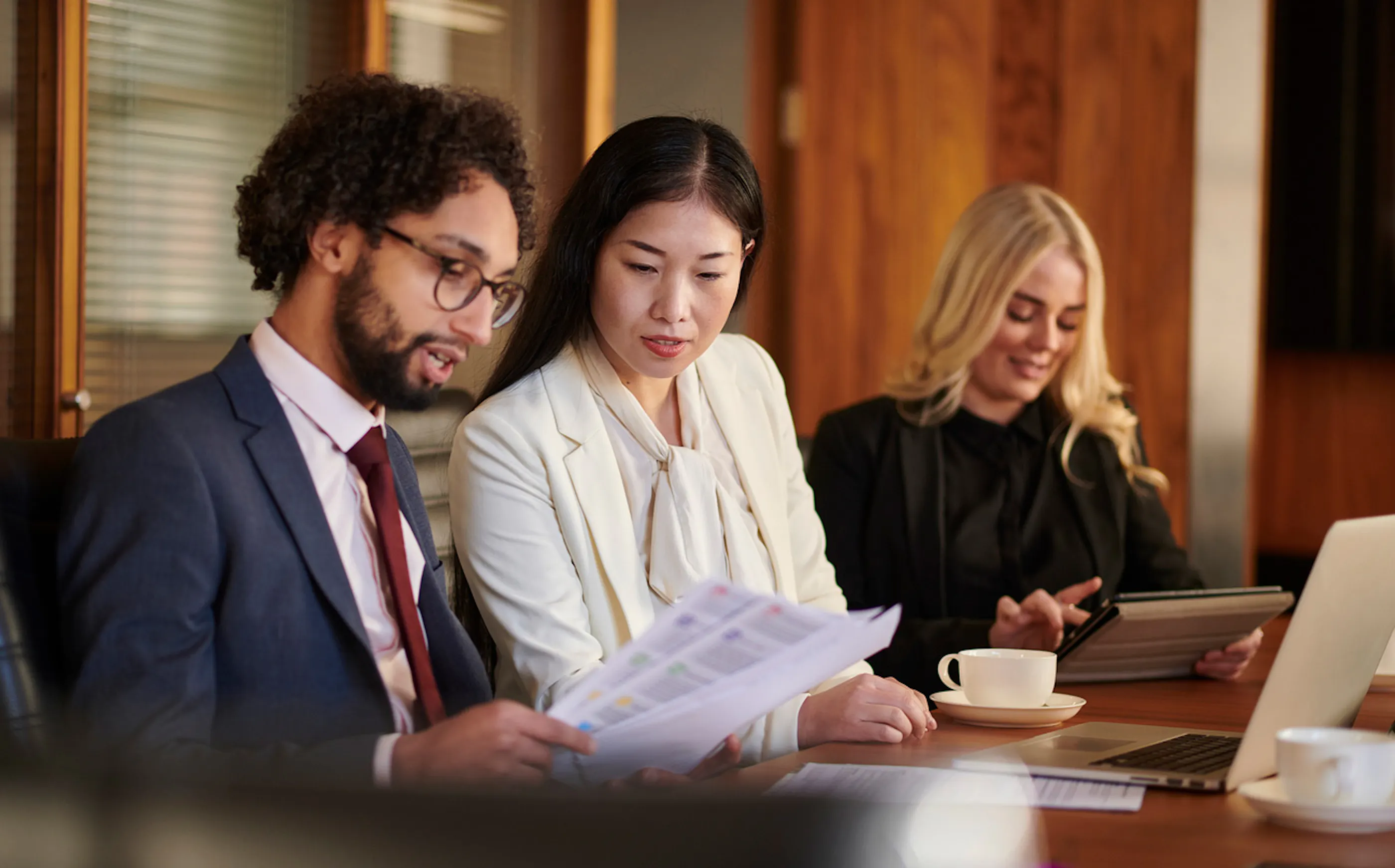three people reviewing documents at a conference table