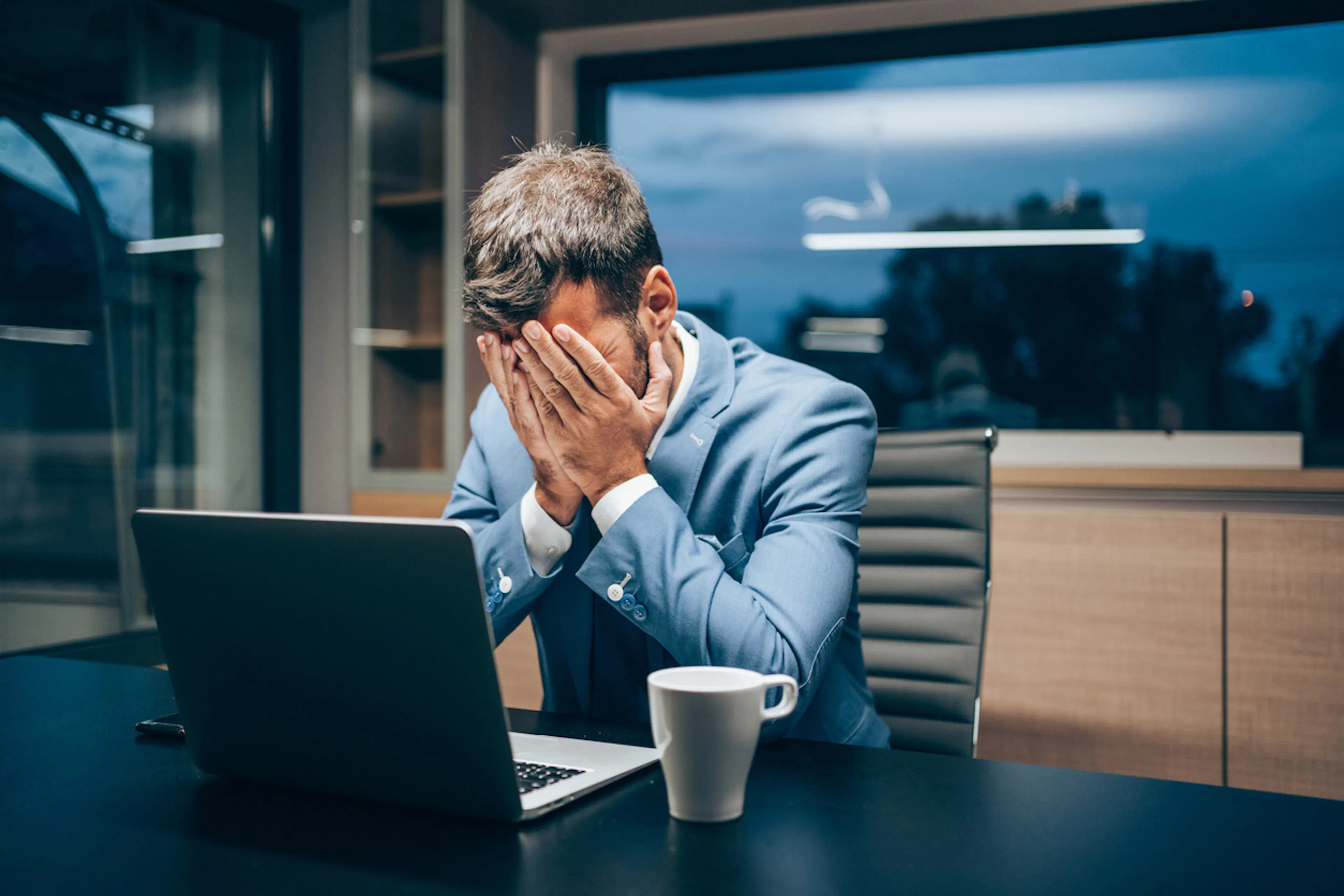 Man at desk with head in hands