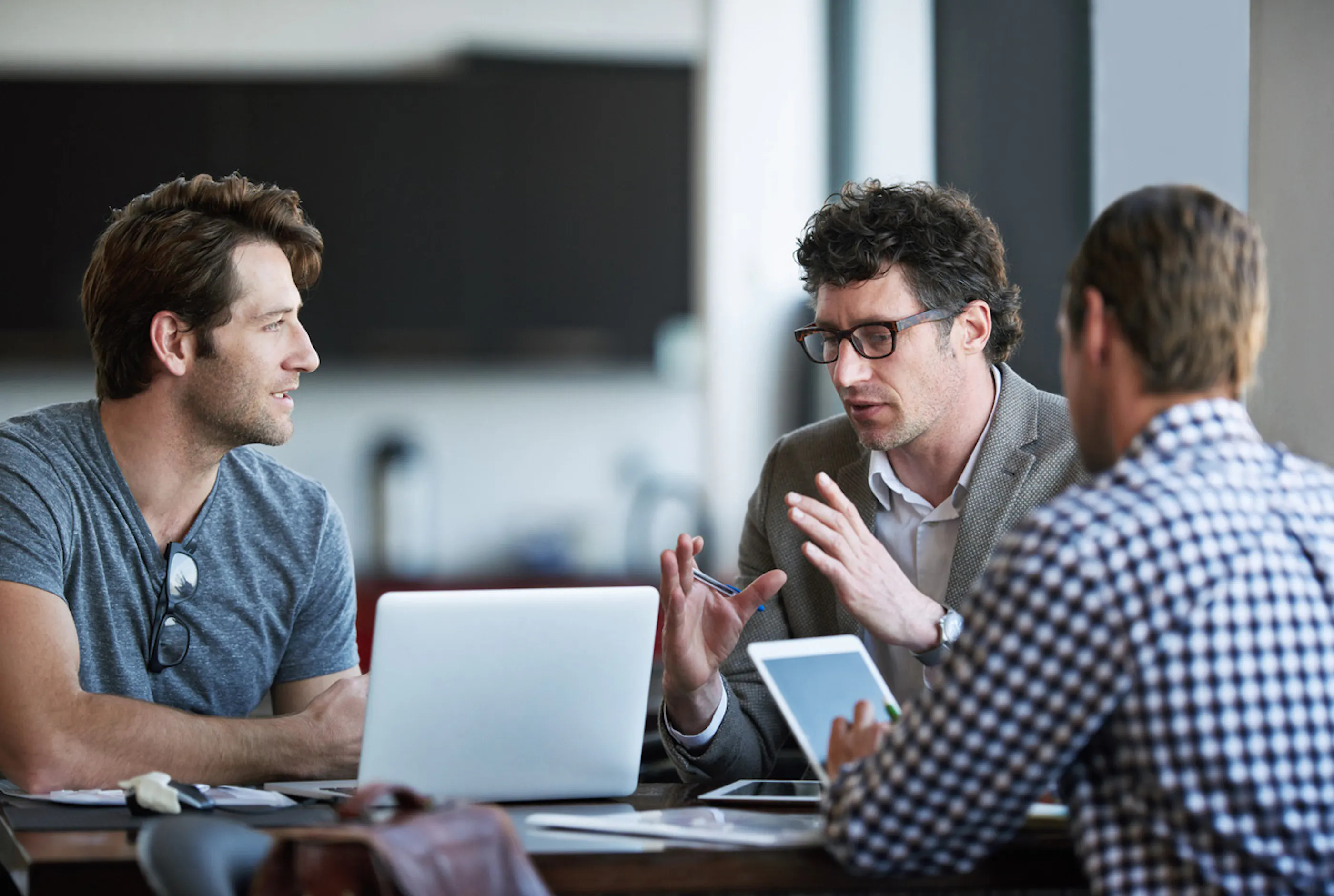 three men working at a conference table