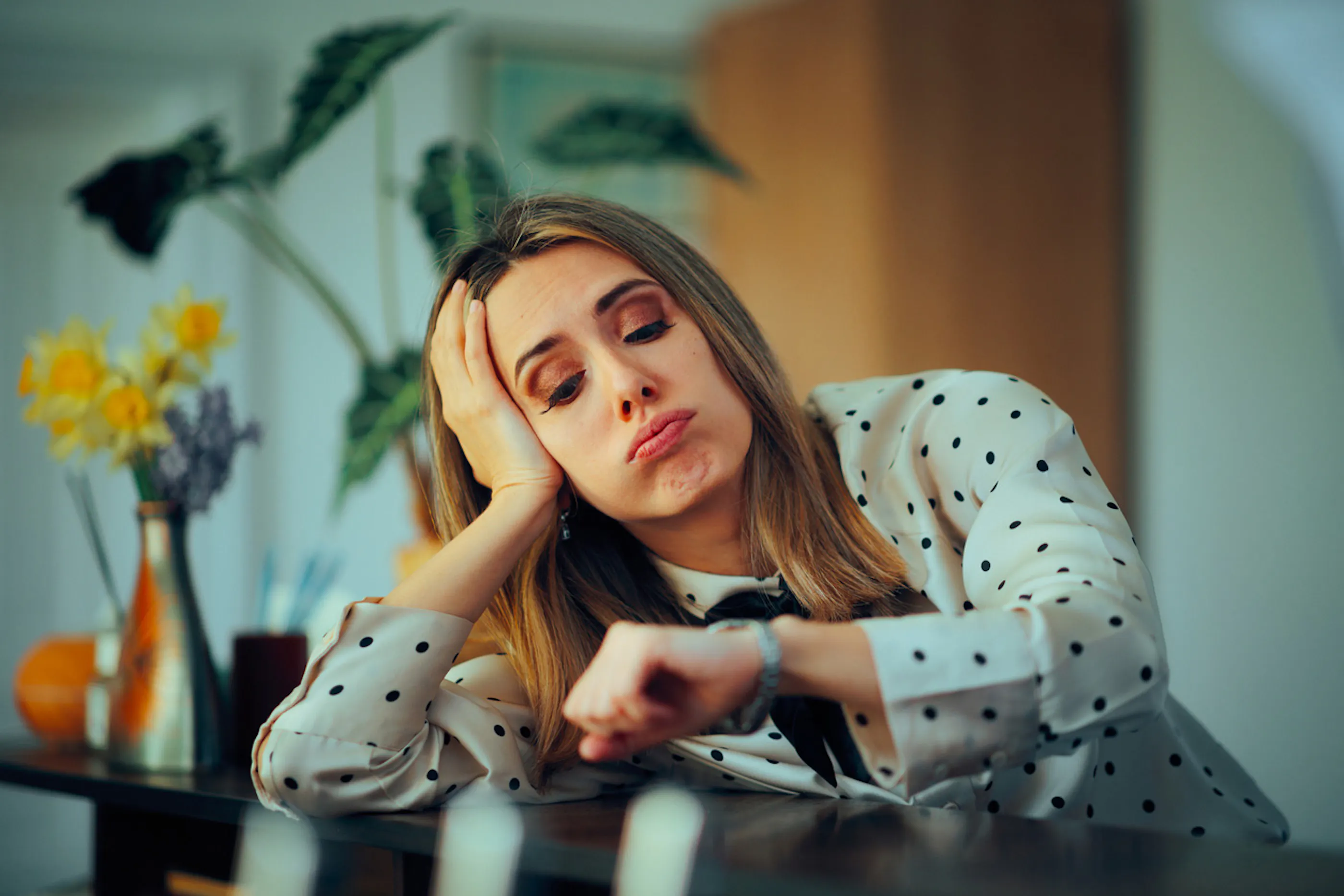 woman looking at her watch with an exasperated expression