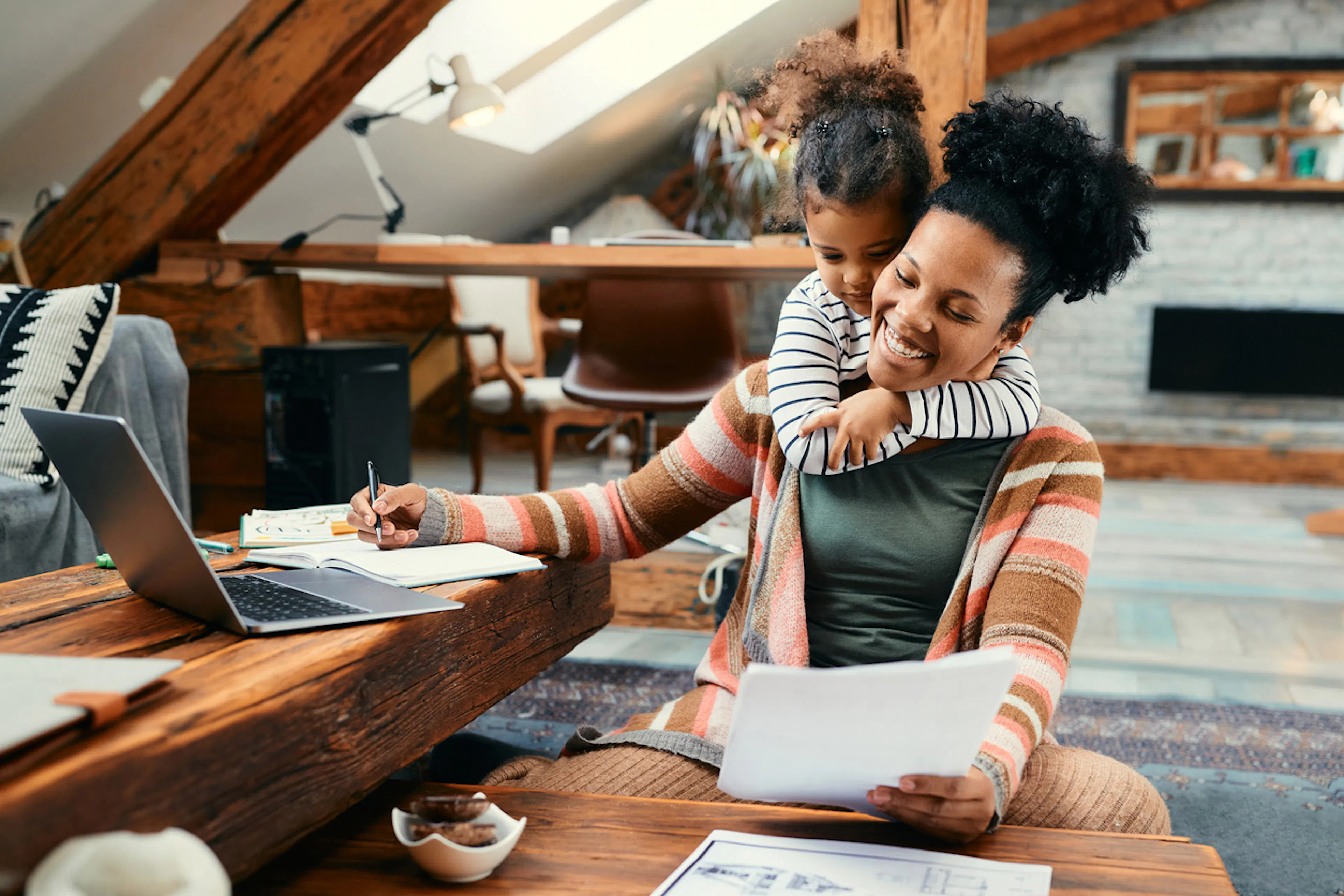 woman working and getting a hug from her child