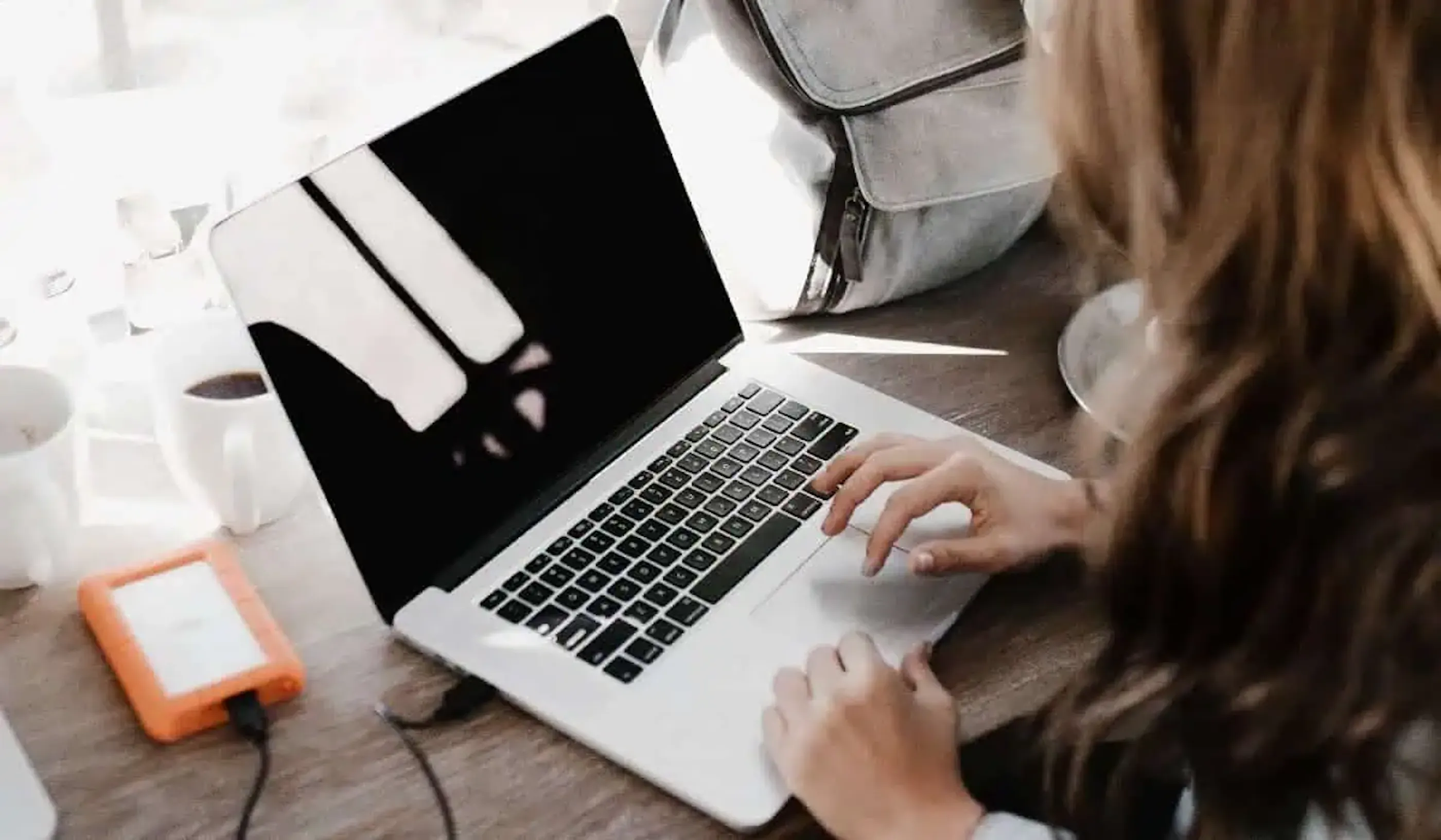 Woman typing on a Macbook laptop computer
