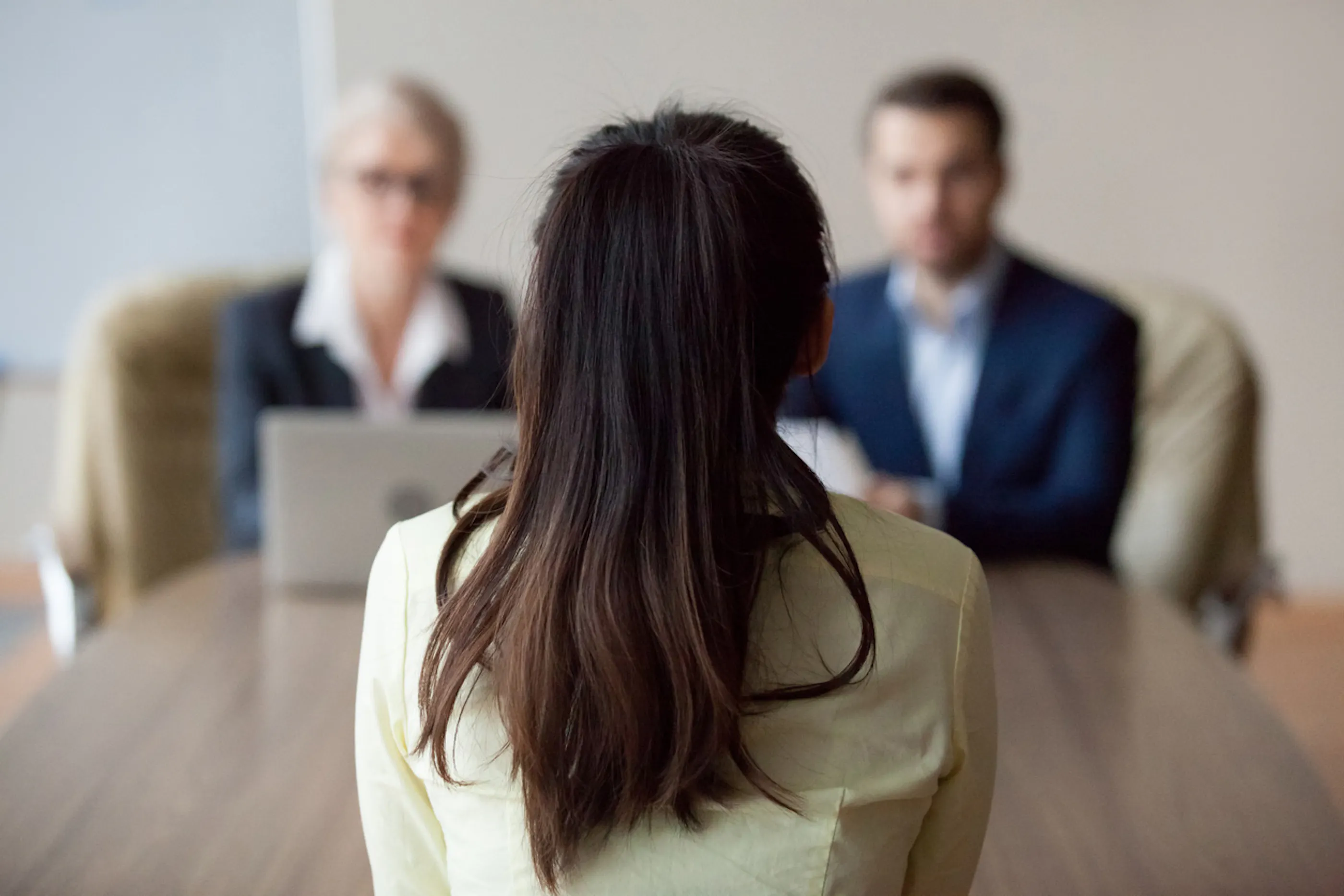 woman being interviewed by two people shown from her perspective