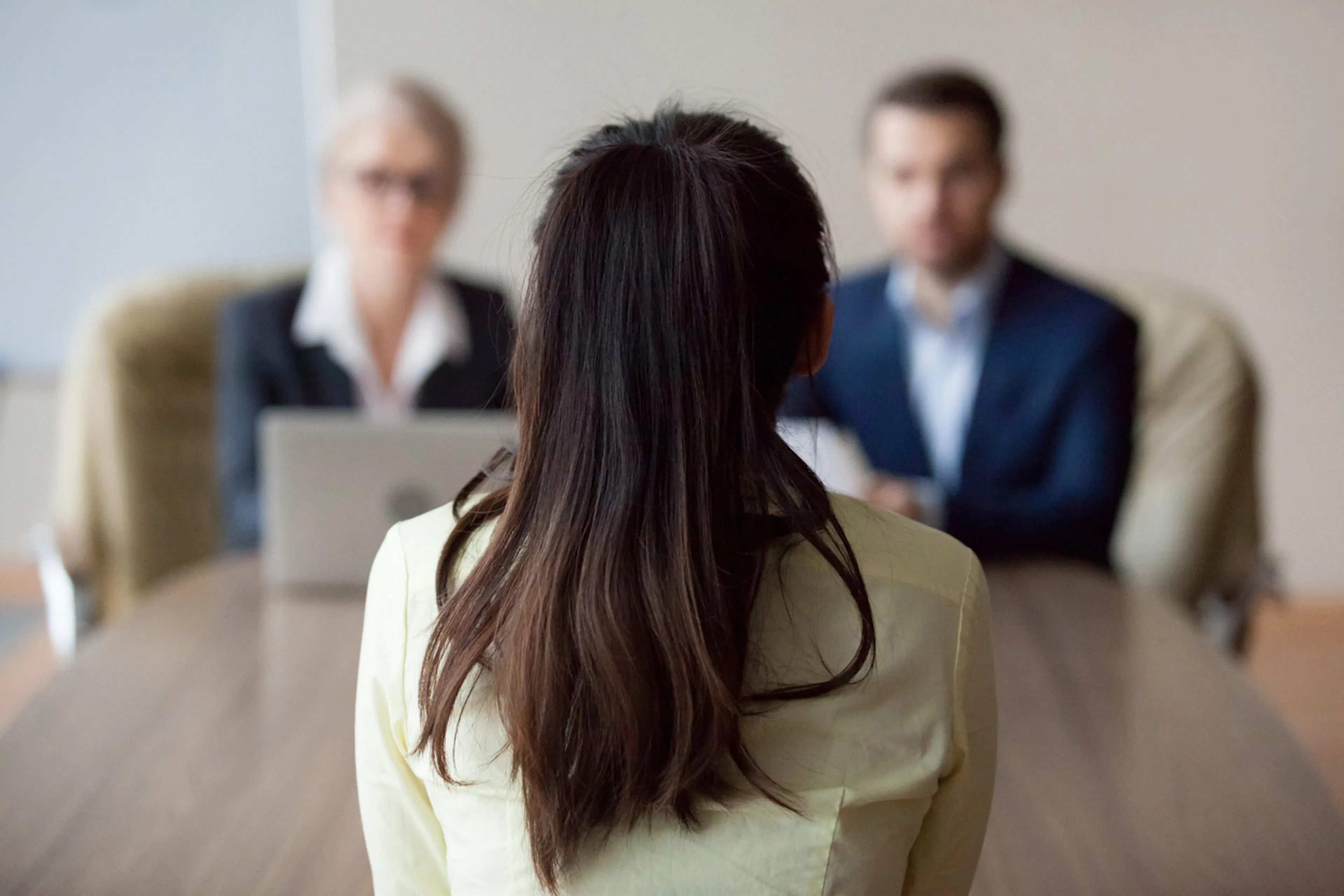 woman being interviewed by two people shown from her perspective