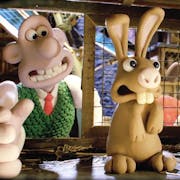 Stop motion animation of a white man with wide mouth putting his hand in a rabbit hutch gingerly towards a shaking brown rabbit; a light brown dog stands upright looking through the wire hutch window