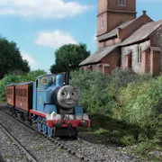 Stop motion animation of a blue train on the tracks riding through greenery past a quaint stone building