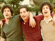 Three identical young men with their arms around each other