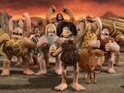 Claymation of a group of characters wearing animal furs in a pre-historic setting