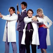 Two white men, one Black man and one white woman stand in hospital uniforms wielding guns
