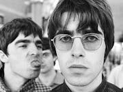 Black and white photo of young men, one in sunglasses, one sticking out his tongue.