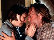 A white woman and white man hold each other and look at each other intently