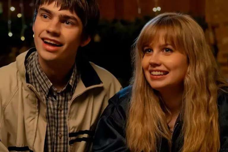 Two white teenagers (a girl and boy) smiling awkwardly