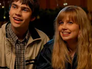 Two white teenagers (a girl and boy) smiling awkwardly