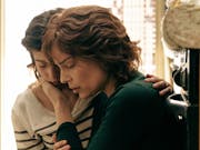 Worried looking woman holds the face of a younger woman