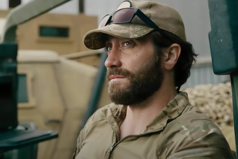 Young bearded man wearing military clothing looks into the distance