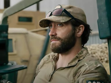 Young bearded man wearing military clothing looks into the distance