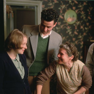 Two women and two men in 50s clothing in a homely working class house 