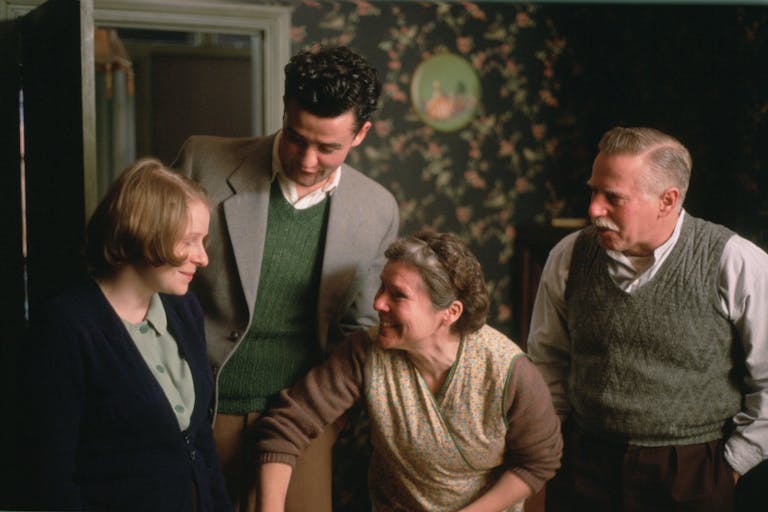 Two women and two men in 50s clothing in a homely working class house