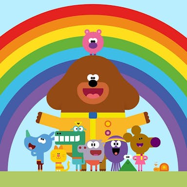 Colourful animation of a large brown dog in scout's leader uniform, surrounded by various small smiling animals in front of a rainbow