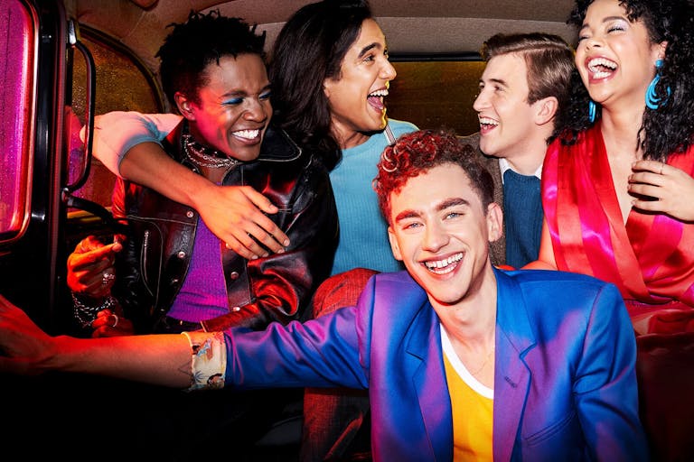 Group of people laughing and smiling in the back of a taxi