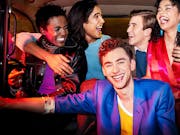 Group of people laughing and smiling in the back of a taxi