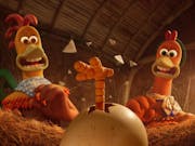 Stop motion animation of a male chicken and a female chicken looking surprised at a small chick's leg, kicking and breaking free of it's egg shell in the hen coop