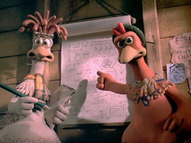 Stop motion animation of two chickens in a hen coop pointing at flip paper with diagrams on plotting their escape
