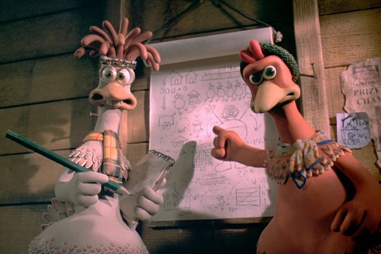 Stop motion animation of two chickens in a hen coop pointing at flip paper with diagrams on plotting their escape