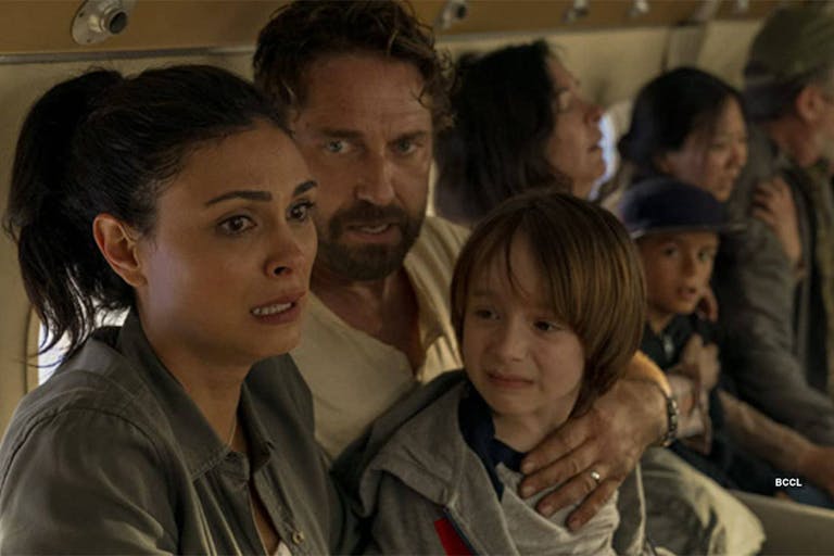 A man, woman and child, hold eachother on a plane, looking very scared. 