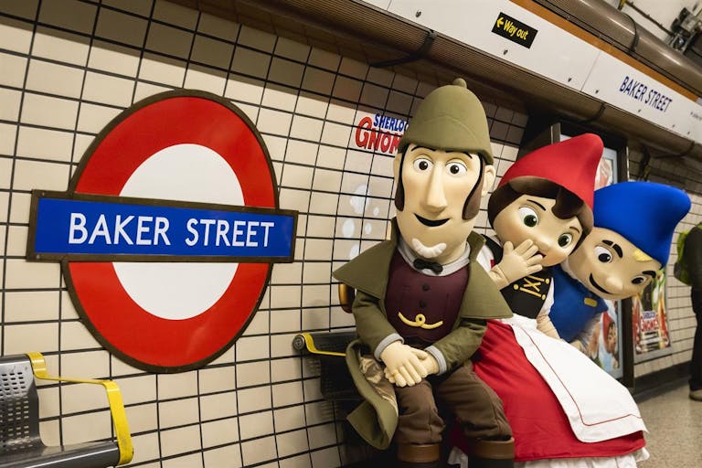 Animated scene of Sherlock Gnomes with two other gnomes, standing in the London Underground next to a sign for Baker Street.