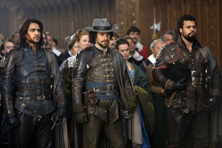 Three men wearing steampunk, leather combat wear in a period setting