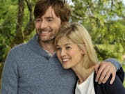 A white male and female middle aged couple embracing and smiling in a sunny garden